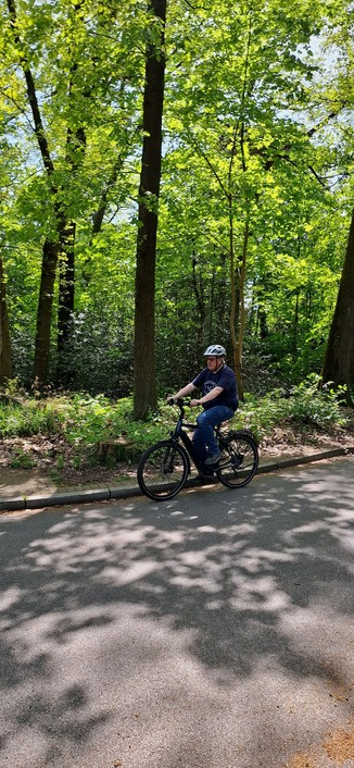 Ralf Sandfuchs fährt auf dem Fahrrad an der Kamera vorbei, im Hintergrund sind Bäume zu sehen.