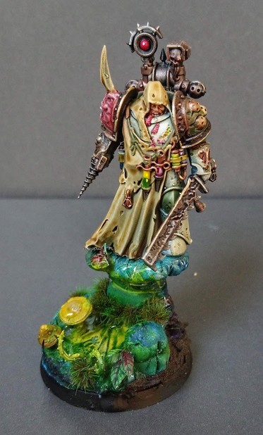 Fully painted miniature of a Death Guard Plague Marine. This one is a Apothecary and he's standing on a greenish swamp base.