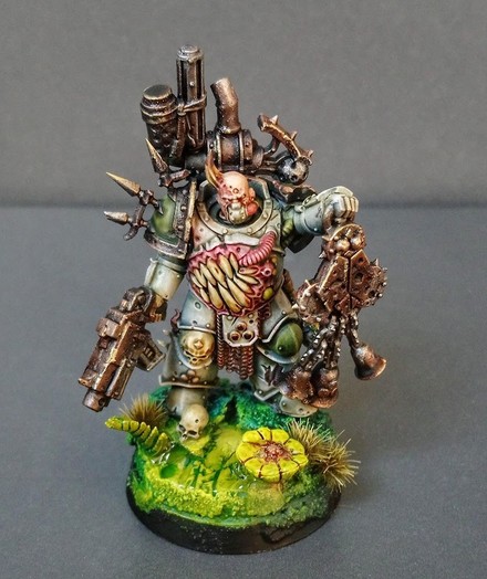 Fully painted miniature of a Death Guard Plague Marine. He's carrying a Nurgle-Symbol-thing and his name is Oleg.